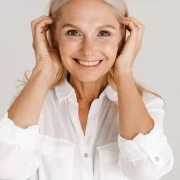 femme d'âge mûr souriante avec les mains sur le dessus des oreilles